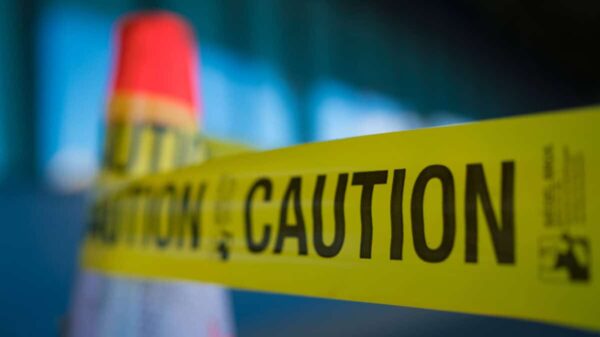 Yellow caution tape attached to traffic cone