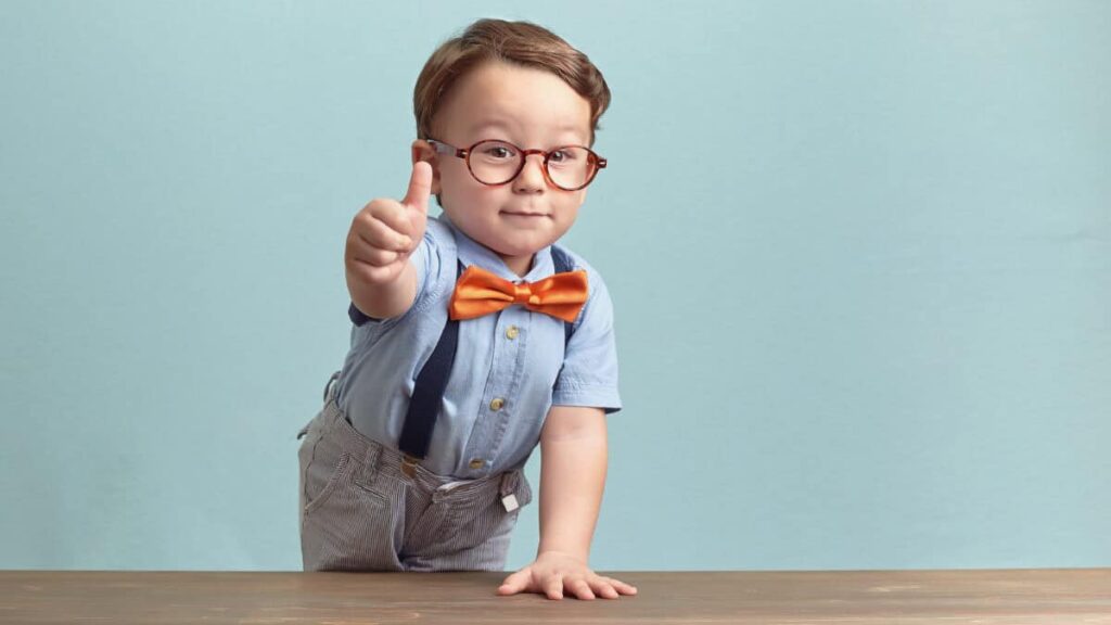 boy in bowtie and glasses gives positive thumbs up