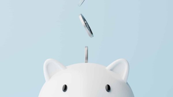 Silver coins fall into a piggy bank.