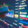 Financial analyst reviews numbers and charts on a screen