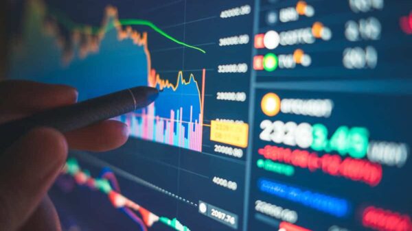 Financial analyst reviews numbers and charts on a screen